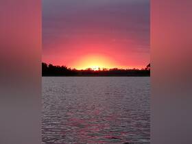 A stunning sunset over the water, casting vibrant colors in the sky — a perfect backdrop for evening boat cruises.