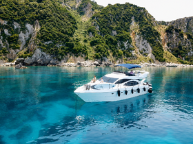 A stunning yacht anchored in crystal-clear waters, surrounded by lush greenery — perfect for exploring scenic coastal destinations.