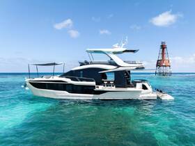 A stunning aerial view of a luxurious yacht cruising through crystal-clear waters, showcasing its sleek design against a picturesque backdrop.