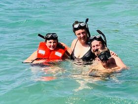 A joyful family enjoys snorkeling in clear waters, showcasing a fun-filled day of swimming and exploration together.