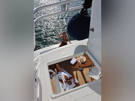 Two women enjoy a luxurious day on a yacht, one sunbathing while the other poses by the water, creating a perfect backdrop for relaxation and celebration.