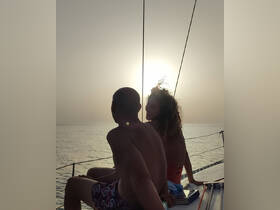 A couple enjoys a romantic moment on a sailboat at sunset, creating a perfect backdrop for unforgettable sailing experiences.