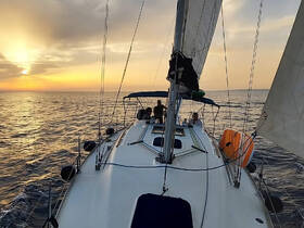 A group enjoys a scenic sunset sail aboard a yacht, capturing the essence of a perfect evening on the water.