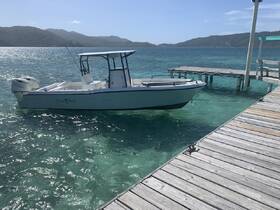 A sleek speedboat named 'Chasin' Tails' docked in clear turquoise waters, surrounded by scenic hills — perfect for a day of adventure on the water.