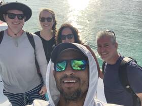 A cheerful group takes a selfie on a boat, capturing a fun moment during their water adventure — perfect for creating lasting memories on the sea.