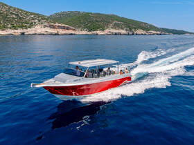 A sleek speedboat cruises through crystal-clear waters, showcasing a group enjoying a day on the water — perfect for adventure seekers and group outings.