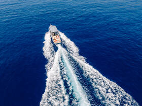A lively group enjoys a thrilling ride on a speedboat, cutting through the deep blue waters — perfect for adventure seekers and water enthusiasts.