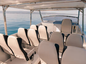 Interior view of a boat's seating area and helm, showcasing comfortable seating arrangements ideal for a day on the water.