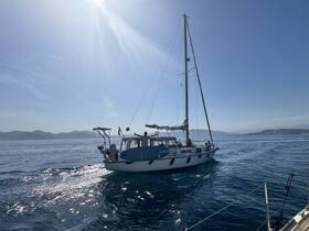 A beautiful sailboat glides through calm waters under a bright sun, showcasing the perfect day for sailing adventures.