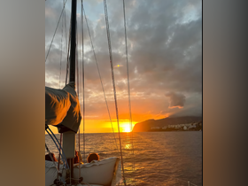 A group enjoys a stunning sunset while sailing, creating a picturesque moment on the water — perfect for romantic evenings or group outings.