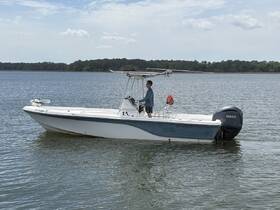 A young man navigates a Yamaha-powered boat on calm waters, showcasing a perfect day for boating adventures.