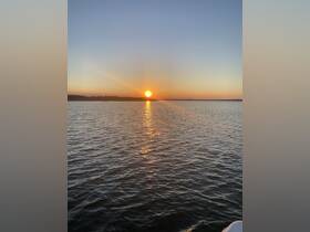 A serene sunset over calm waters, showcasing the beauty of nature — perfect for peaceful evening boat rides.