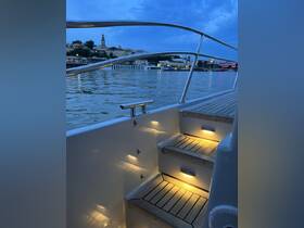 A beautifully lit staircase inside a boat, showcasing elegant wooden steps and ambient lighting — perfect for evening cruises.