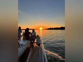 A group of friends enjoys a picturesque sunset aboard a boat, creating a perfect backdrop for memorable moments on the water.
