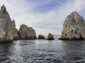 A stunning view of dramatic rock formations along the coastline, showcasing the natural beauty of the area — perfect for sightseeing and exploration by boat.
