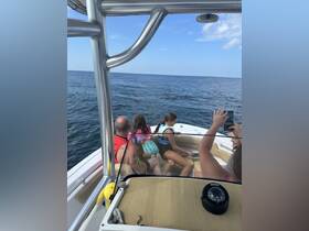 A family enjoys a day on the water, capturing memories aboard their boat while taking in the ocean views. Perfect for summer adventures and family outings.