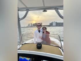 A couple enjoys a romantic moment on a boat at sunset, capturing the perfect backdrop for memorable experiences on the water.