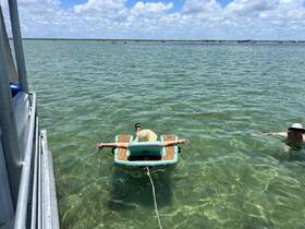 Two friends enjoy a sunny day floating in clear waters, showcasing the perfect summer getaway experience.