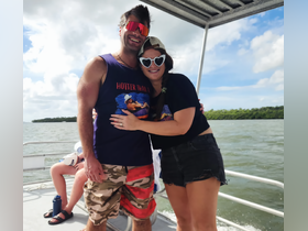 A cheerful couple poses for a fun photo on a boat, capturing the joy of their day on the water — perfect for memorable outings and celebrations.