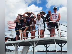 A lively group of friends poses for a fun photo on a pontoon boat, showcasing their excitement for a day on the water.