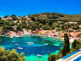 A stunning view of a picturesque harbor surrounded by vibrant houses and lush greenery, showcasing the beauty of coastal living.
