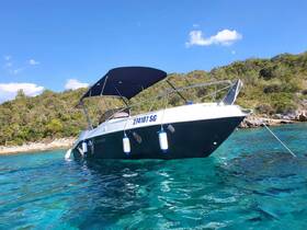 A sleek boat anchored in crystal-clear waters, showcasing its elegant design against a lush green backdrop — perfect for a day of exploration on the water.