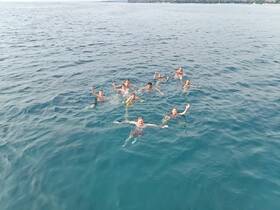 A lively group enjoys a refreshing swim in the ocean, capturing the joy of summer adventures on the water.