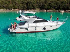 A lively group enjoys a sunny day on a yacht, with some swimming in the crystal-clear turquoise waters — perfect for summer fun and relaxation.