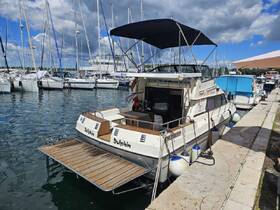 A well-maintained yacht named 'Dolphin' docked at a marina, surrounded by other boats and reflecting the clear blue sky.