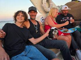 A joyful family gathering on a boat, enjoying food and each other's company, with a dog joining the fun — perfect for memorable moments on the water.