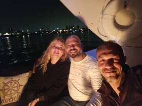 A cheerful group enjoys a night out on the water, capturing memories aboard a boat under the stars — perfect for celebrations and gatherings.