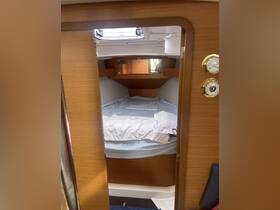A cozy cabin interior featuring a comfortable bed and wooden finishes, perfect for relaxing on a boat getaway.