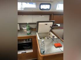 Interior view of a boat's kitchen area, featuring a sink, stove, and storage, ideal for meal preparation while on the water.