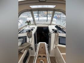 A cozy view of the helm area inside a boat, featuring a well-organized console and a touch of greenery with a potted plant, perfect for a relaxing day on the water.