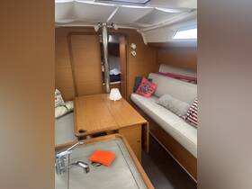 Interior view of a cozy boat cabin featuring a dining area and comfortable seating, perfect for relaxing during your nautical adventures.