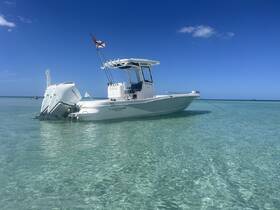 A sleek center console boat anchored in clear waters, showcasing its design against a stunning blue sky — perfect for day trips and water adventures.