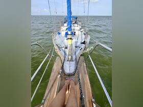 A view from the bow of a sailboat with feet visible, showcasing the vessel's structure as it navigates through open waters.