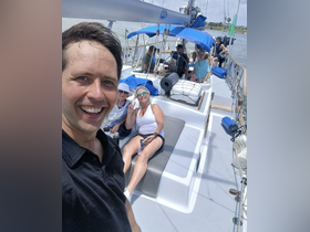 A cheerful group enjoys a sailing trip, capturing fun moments on deck. Perfect for social gatherings and memorable experiences on the water.