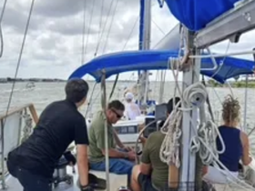 A group of friends enjoys a sailing experience on a boat, with scenic views and camaraderie as they navigate the waters.