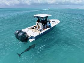 A boat navigates through crystal-clear waters, with passengers enjoying the ride — perfect for fishing or leisure trips in stunning surroundings.