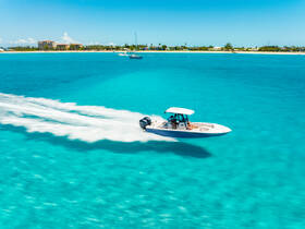 A speedboat glides through the stunning turquoise waters, showcasing the thrill of boating adventures in a tropical paradise.