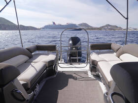 Interior view of a spacious pontoon boat featuring comfortable seating, perfect for relaxing while enjoying the scenic ocean views.