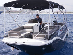 A Bayliner speedboat is showcased with a captain at the helm, cruising through clear waters — perfect for leisurely outings or water sports adventures.