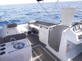 A spacious interior view of a boat featuring comfortable seating and a helm area, perfect for relaxing and navigating on the water.