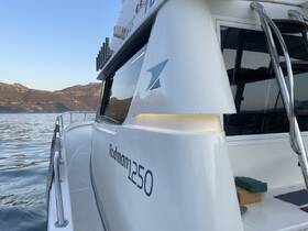 A close-up view of the side of a Rodman 250 boat, showcasing its sleek design against a serene water backdrop, perfect for boating enthusiasts.