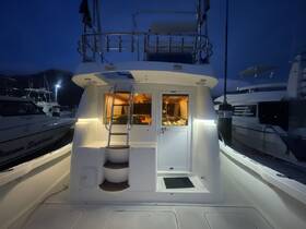 A cozy view of the boat's interior at night, showcasing the helm and seating area illuminated, perfect for evening cruises or overnight stays.