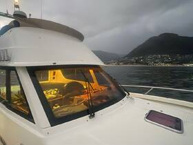 A cozy view of the helm area inside a boat, showcasing the cabin's layout and equipment, perfect for navigating the waters.
