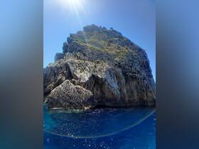 A stunning view of a rocky cliff rising from the deep blue ocean, showcasing the natural beauty of the coastline — perfect for scenic boat tours.
