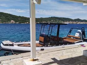 A sleek speedboat docked at a picturesque waterfront, showcasing its modern design against a backdrop of lush hills and clear waters.