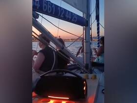 A group enjoys a beautiful sunset while sailing, creating a perfect atmosphere for relaxation and celebration on the water.